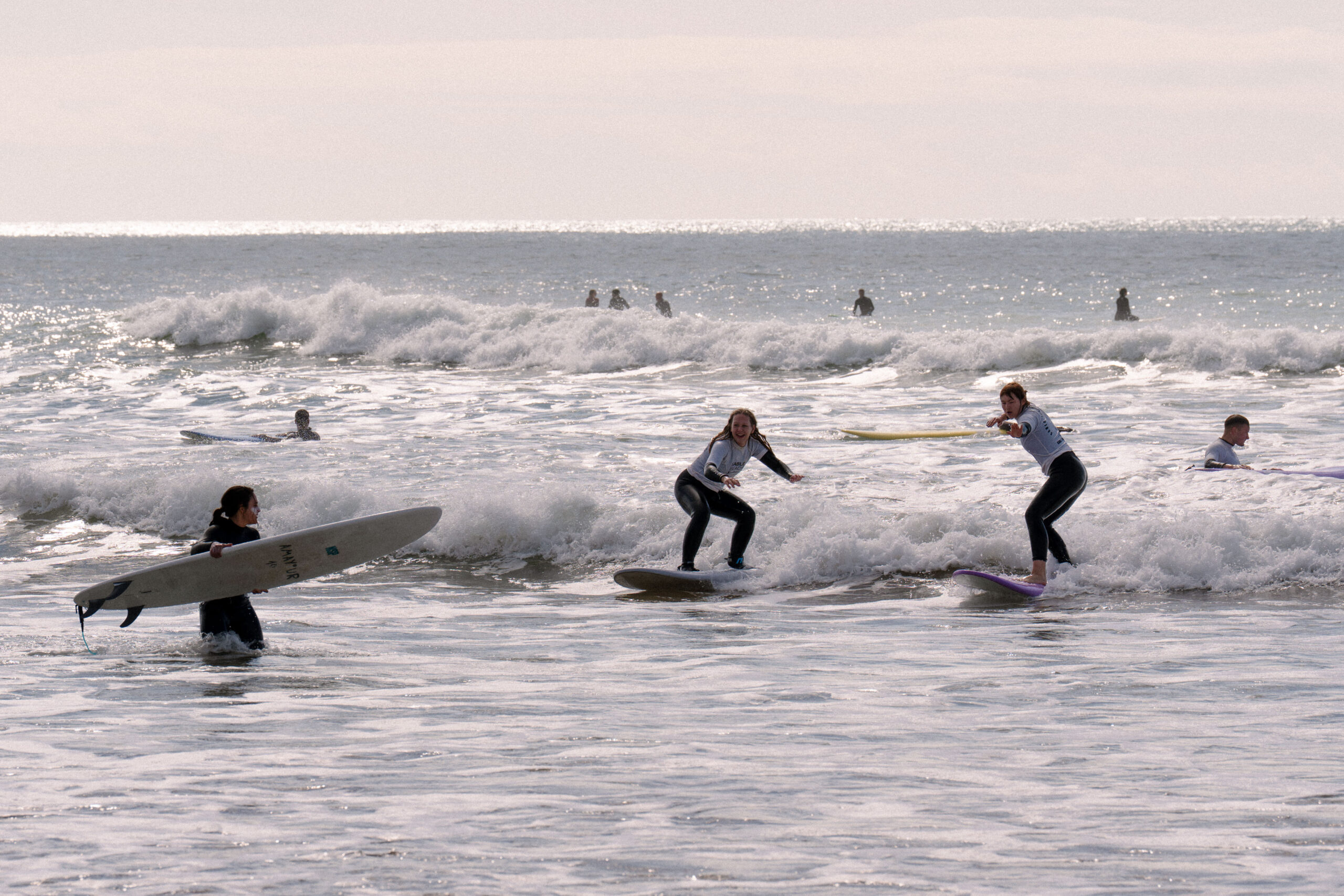 Surf instructor helping beginner surfer in Tamraght